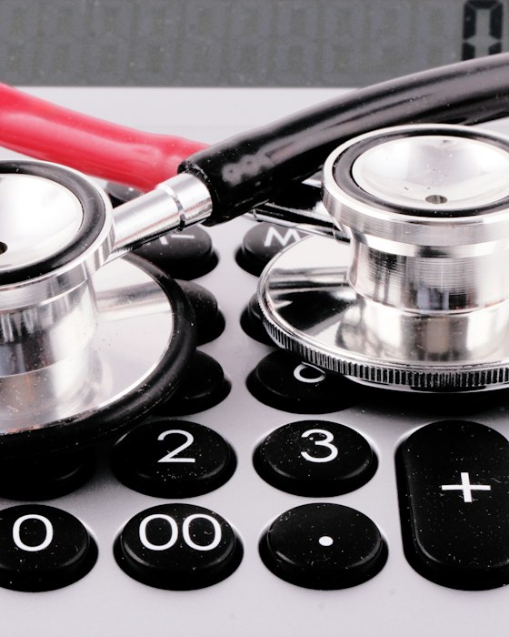 A stethoscope resting on a calculator